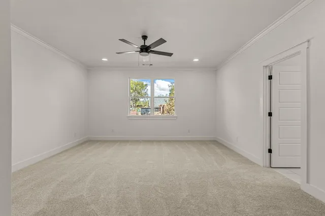 an empty room with a window and a ceiling fan