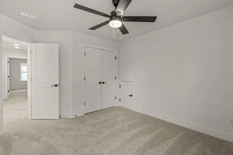 an empty room with chandelier fan