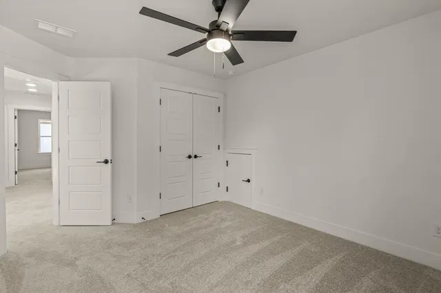 an empty room with chandelier fan