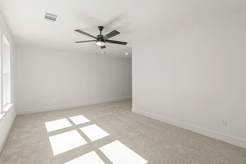 an empty room with a window and a fan