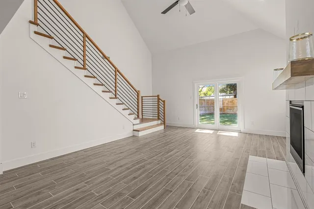 a view of an empty room with wooden floor and a fireplace