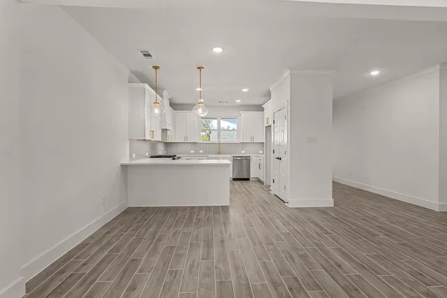 a large kitchen with a wooden floor and window