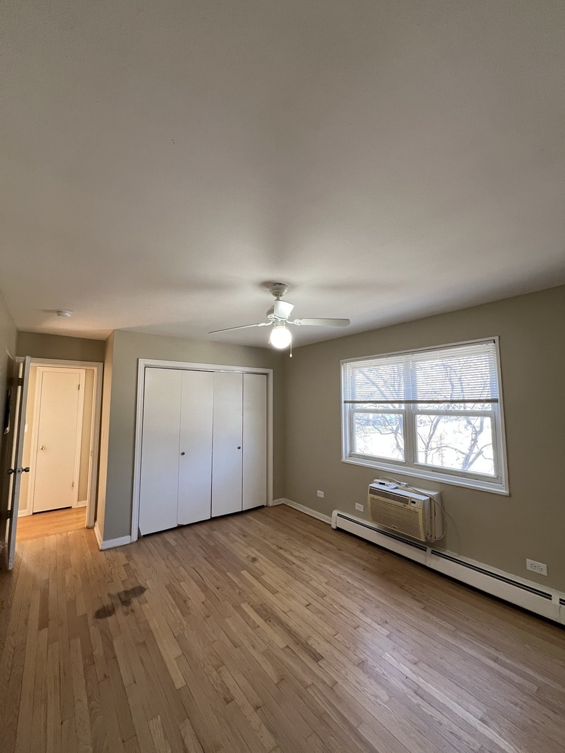 560 Princeton Street, Unit A2W Des Plaines, IL 60016 - Photo 13 of 15 an empty room with wooden floor and windows
