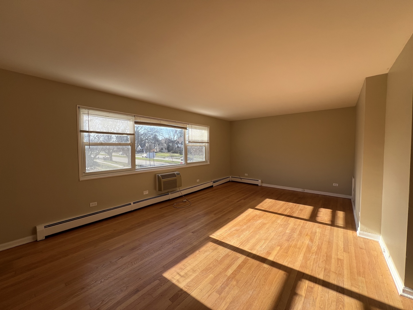560 Princeton Street, Unit A2W Des Plaines, IL 60016 - Photo 7 of 15 a view of an empty room with wooden floor and a window