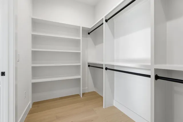 a view of walk in closet with empty racks
