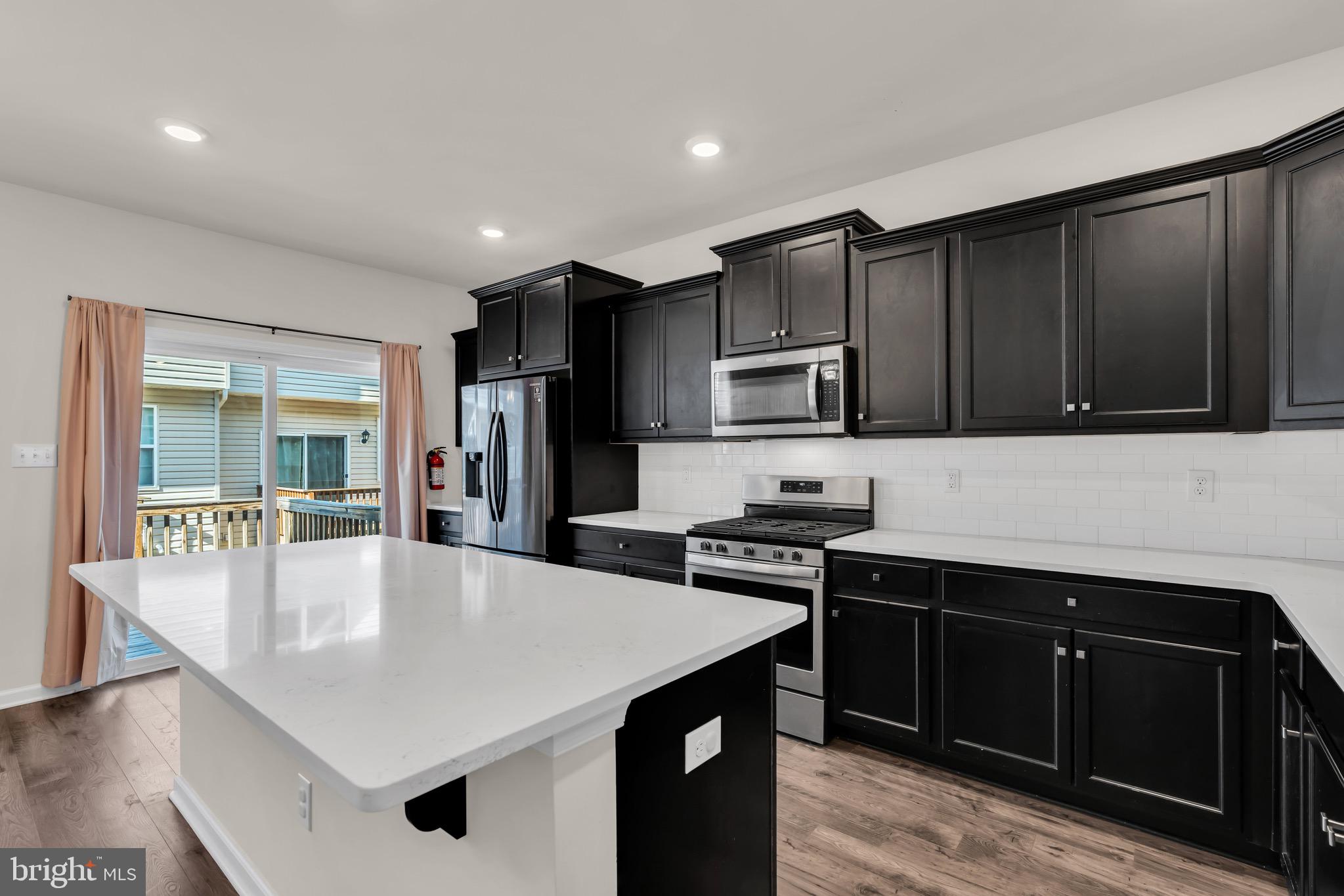 504 East International Road Monroe Township, NJ 08831 - Photo 2 of 37 a kitchen with stainless steel appliances a stove a sink a microwave a refrigerator and cabinets