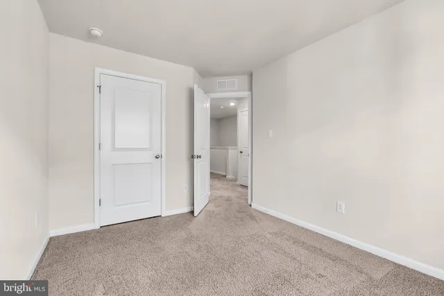 a view of an empty room and closet area