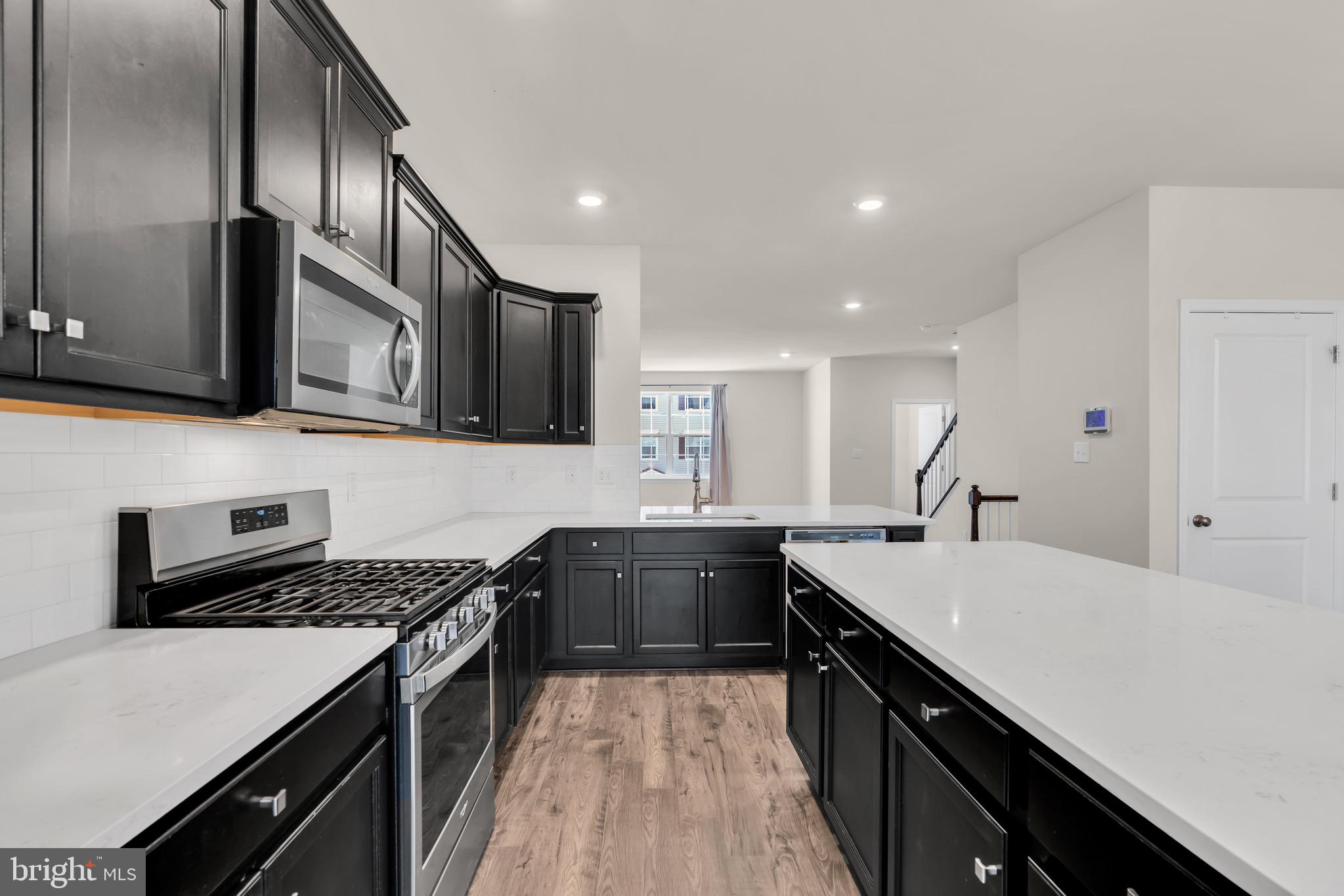 504 East International Road Monroe Township, NJ 08831 - Photo 3 of 37 a kitchen with a stove sink and cabinets