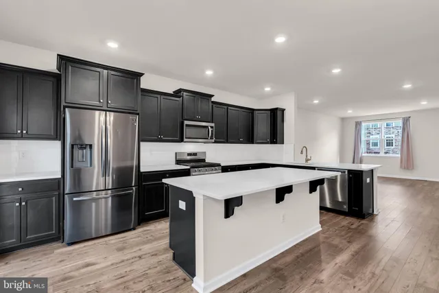 a kitchen with kitchen island a sink stainless steel appliances and cabinets