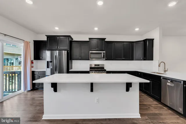 a kitchen with stainless steel appliances a refrigerator sink and microwave