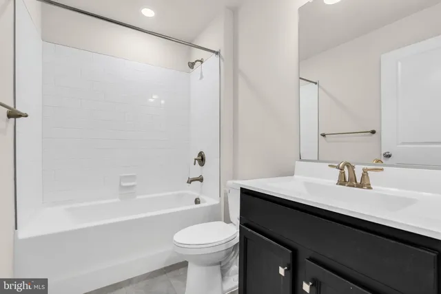 a bathroom with a sink a toilet a mirror and shower