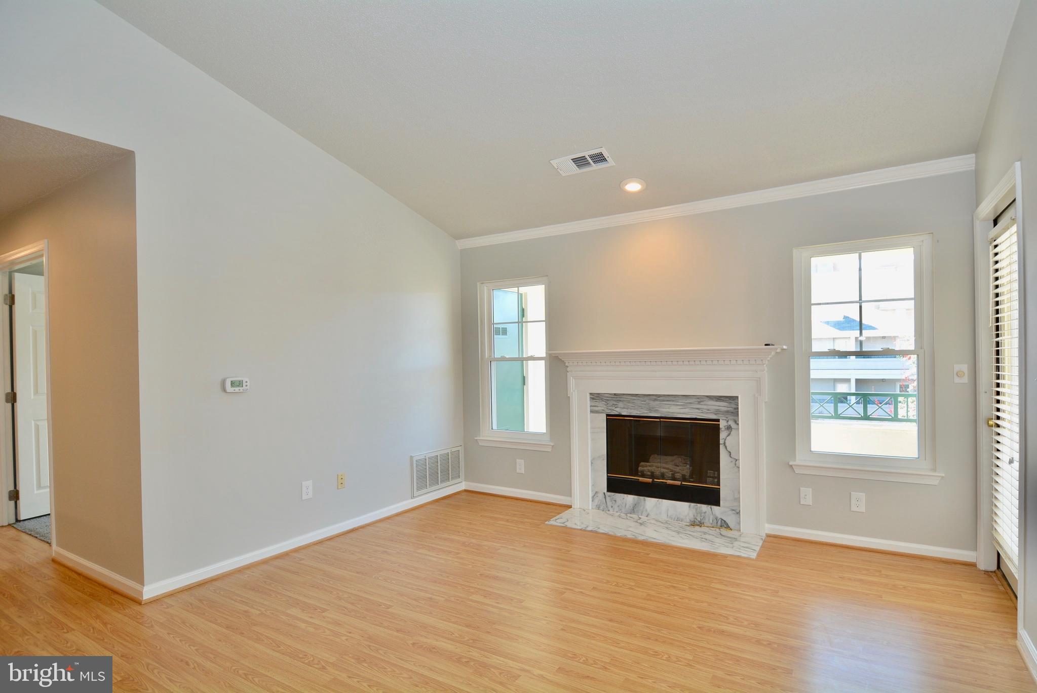 12000 Taliesin Place, Unit 36 Reston, VA 20190 - Photo 16 of 36 a view of an empty room with wooden floor fireplace and a window