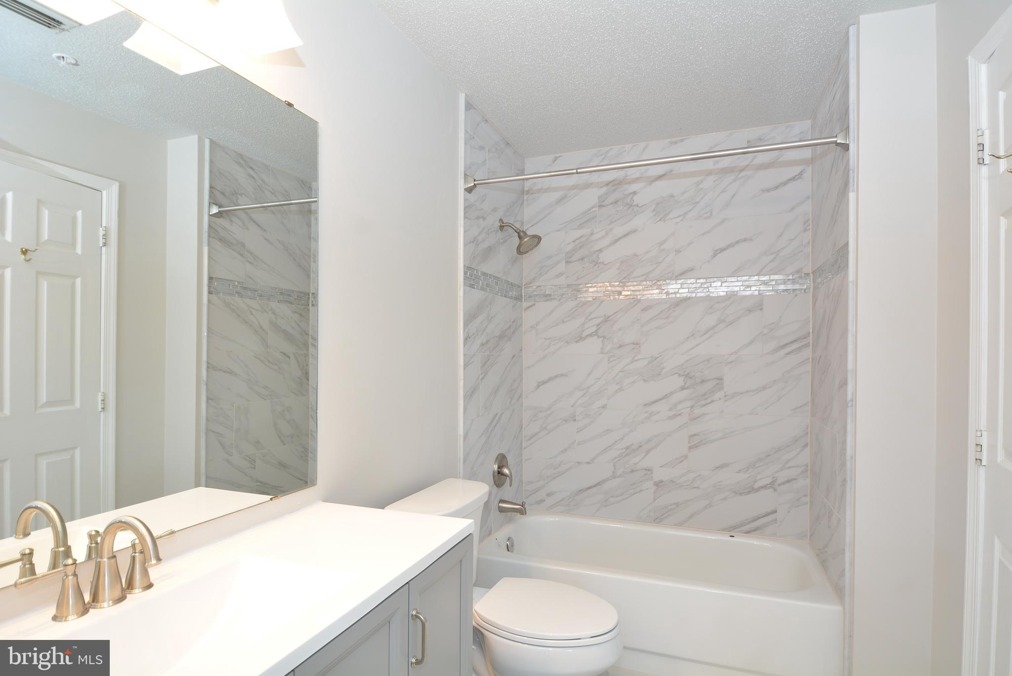 12000 Taliesin Place, Unit 36 Reston, VA 20190 - Photo 25 of 36 a bathroom with a granite countertop bathtub shower sink vanity and toilet