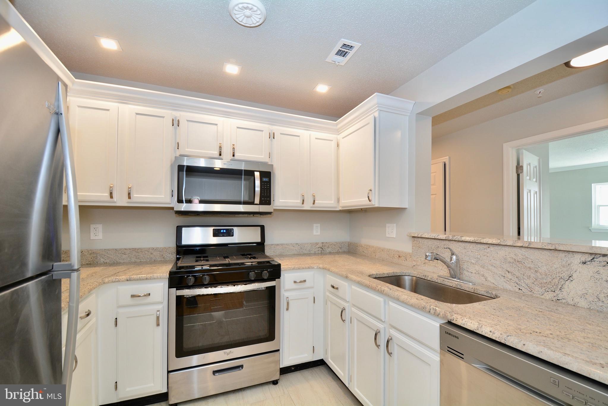 12000 Taliesin Place, Unit 36 Reston, VA 20190 - Photo 6 of 36 a kitchen with stainless steel appliances granite countertop a sink stove and refrigerator