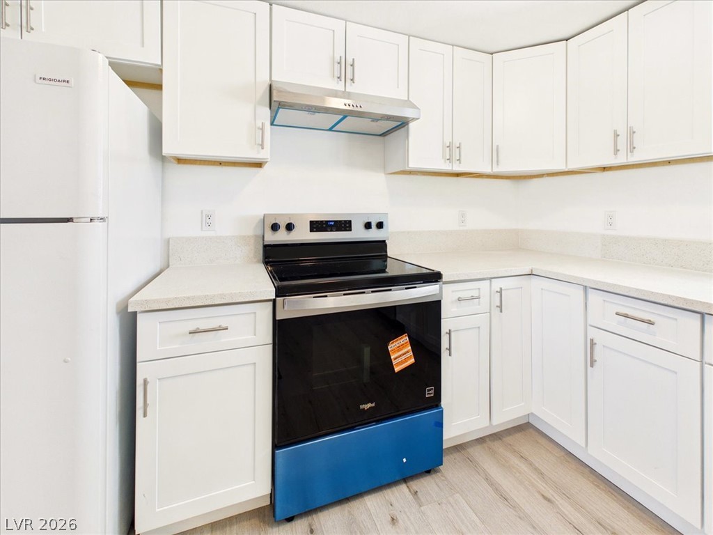 4081 Retread Road Pahrump, NV 89048 - Photo 21 of 98 A well-appointed kitchen features white cabinetry, sleek countertops, and modern appliances, offering a clean and efficient culinary space.