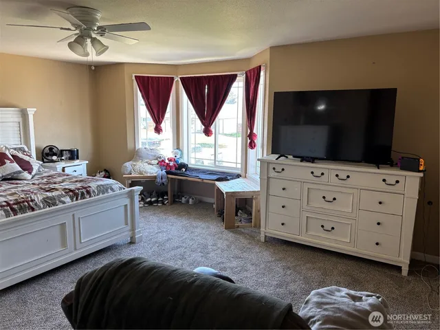 a bedroom with a bed and a flat screen tv