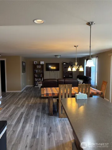 a dining room with wooden floor a glass table and chairs
