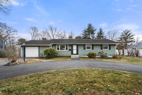 a front view of house with yard and trees around