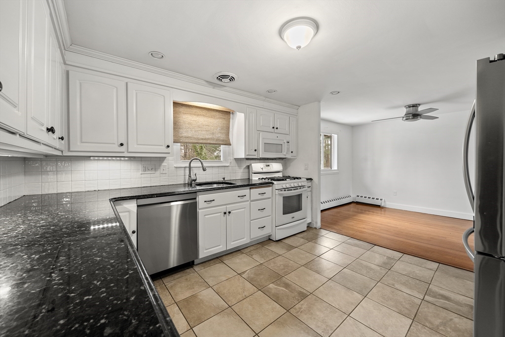 276 Oak Street Brockton, MA 02301 - Photo 9 of 42 a kitchen with granite countertop a stove a sink and a refrigerator