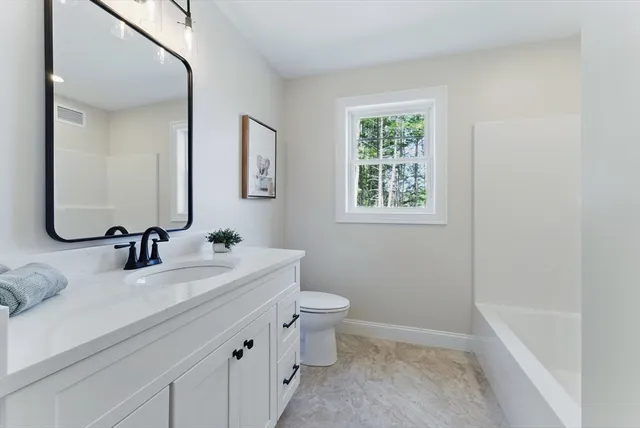 a bathroom with a double vanity sink toilet and a mirror