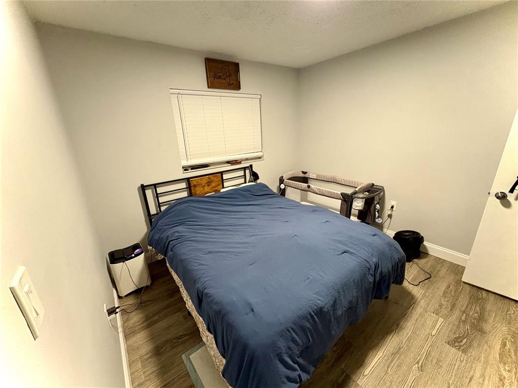 8501 Paxton Drive Port Richey, FL 34668 - Photo 7 of 17 a bedroom with a bed and a flat tv screen on a dresser