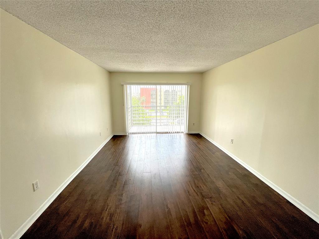 2800 Northwest 56th Avenue, Unit F403 Lauderhill, FL 33313 - Photo 2 of 11 an empty room with wooden floor and windows