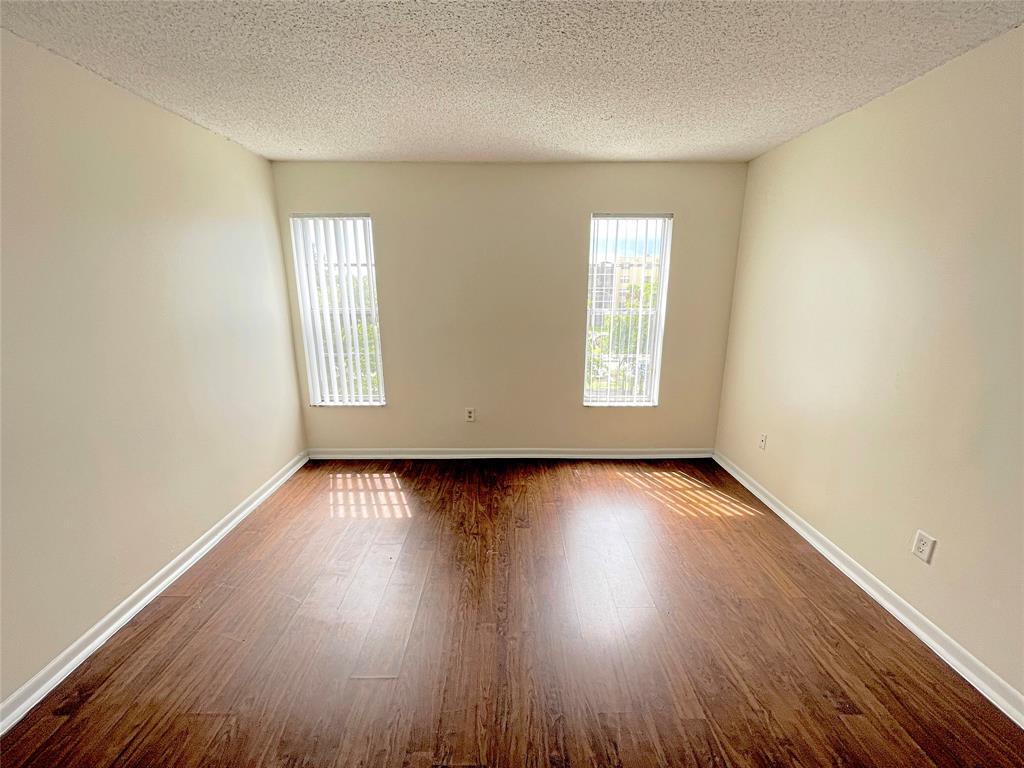 2800 Northwest 56th Avenue, Unit F403 Lauderhill, FL 33313 - Photo 4 of 11 an empty room with wooden floor and windows
