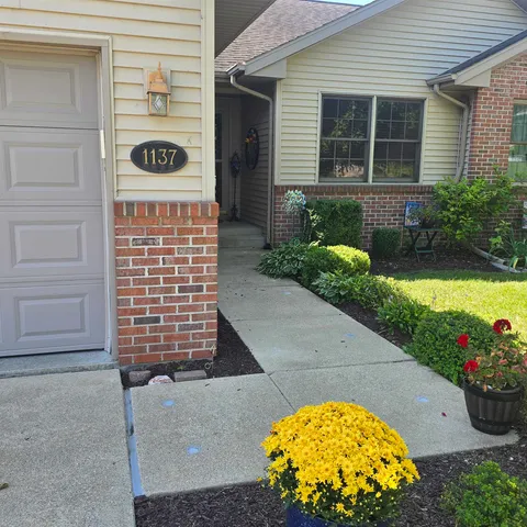 a front view of a house with a swimming pool and garden