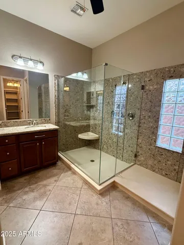 a bathroom with a granite countertop sink and a large mirror