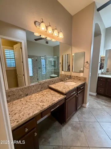 a bathroom with a granite countertop sink a toilet and shower