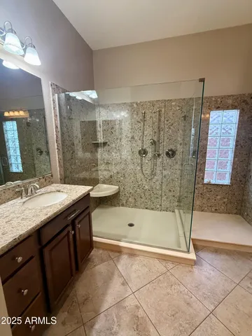 a bathroom with a granite countertop sink and a mirror