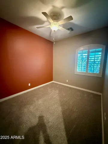 an empty room with a window and a fan