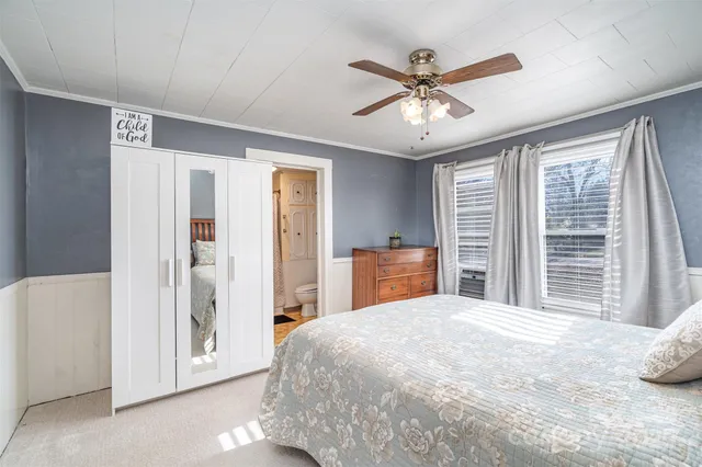 a bedroom with a large bed and a chandelier