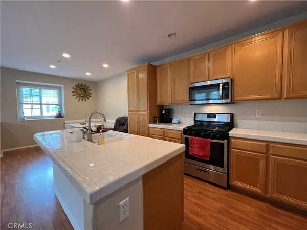 a kitchen with sink a microwave and wooden cabinets