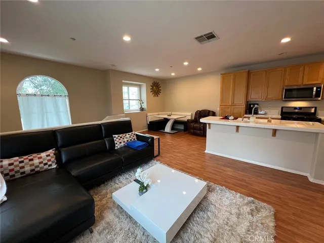 a living room with furniture and a wooden floor