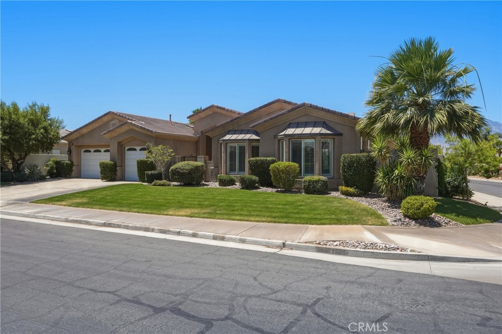 9 Orleans Road Rancho Mirage, CA 92270 - Photo 3 of 71 a front view of a house with a yard and palm trees
