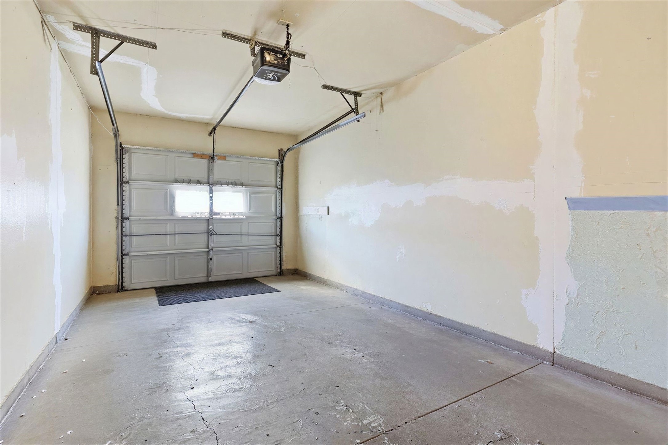 5707 Waltrip Street Houston, TX 77087 - Photo 13 of 15 This photo shows a clean, single-car garage with a concrete floor and a ceiling-mounted garage door opener.