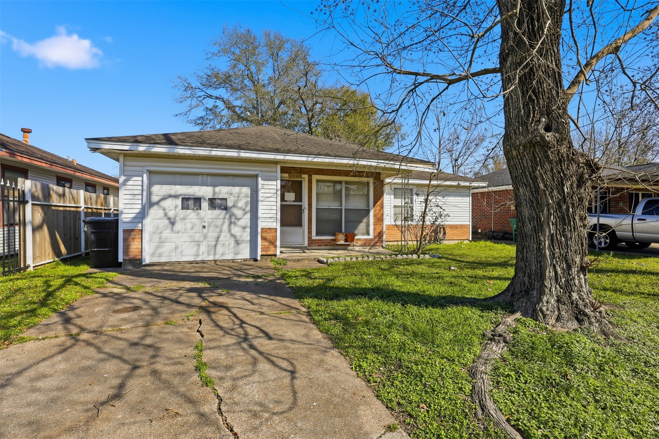5707 Waltrip Street Houston, TX 77087 - Photo 2 of 15 A charming single-story home with a front garage, featuring a driveway and a spacious front yard with mature trees. The exterior is a blend of brick and siding, offering a cozy and welcoming appearance. Ideal for those seeking a quaint and comfortable living space.