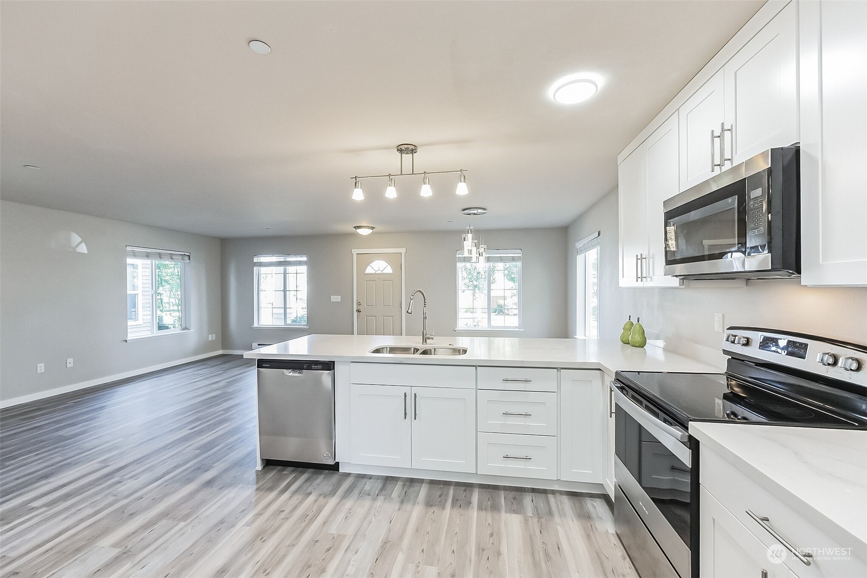 3077 Walker Road DuPont, WA 98327 - Photo 7 of 30 a kitchen with stainless steel appliances a sink wooden floor stove top oven and cabinets