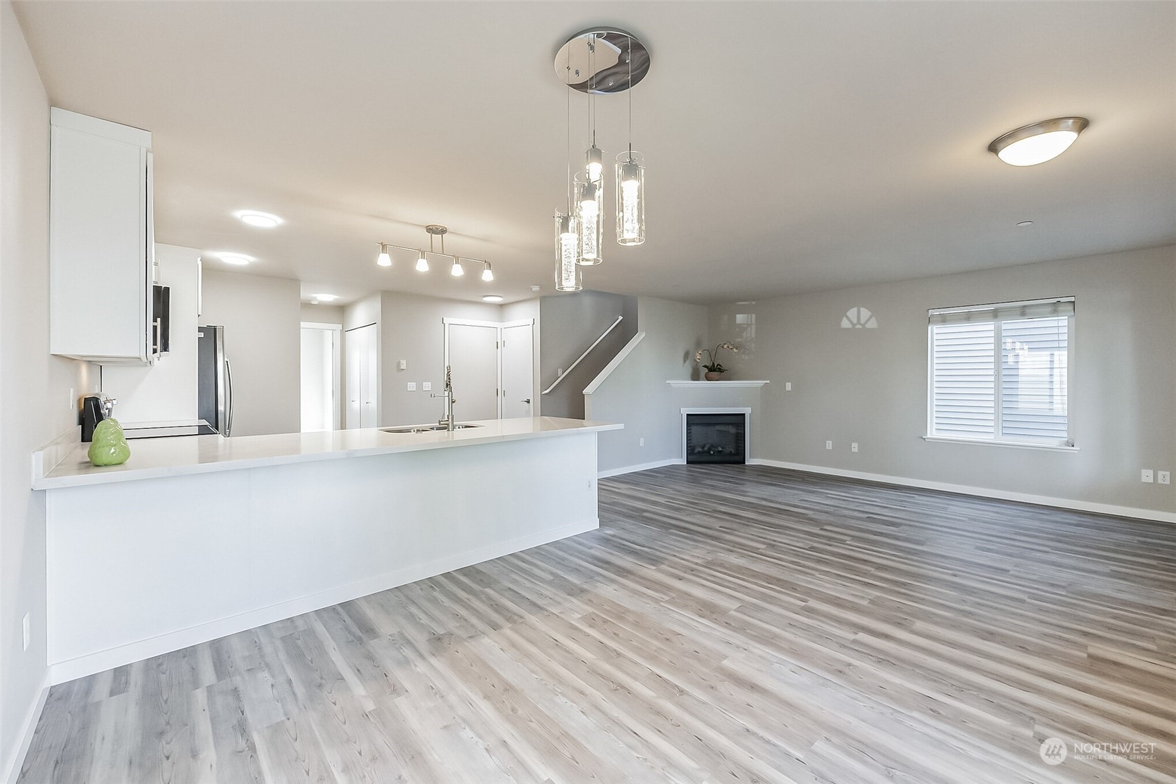 3077 Walker Road DuPont, WA 98327 - Photo 9 of 30 a view of a kitchen with kitchen island a sink wooden floor and a chandelier