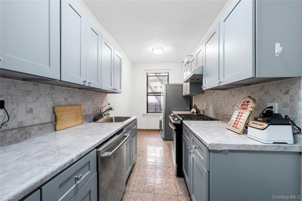 43-33 48th Street, Unit 1B Queens, NY 11104 - Photo 7 of 13 a kitchen with a sink a stove and cabinets