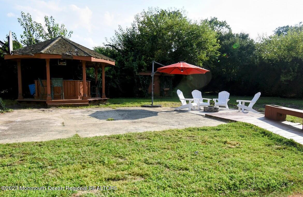 40 Alan Terrace Howell, NJ 07731 - Photo 45 of 48 a patio with a table and chairs under an umbrella