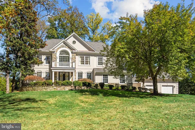 a front view of a house with a garden and trees