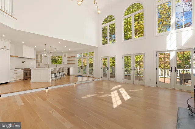 a kitchen with stainless steel appliances granite countertop a sink a stove a refrigerator a island with a dining table and chairs