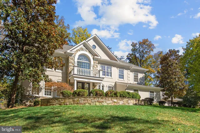 a front view of a house with a garden and trees