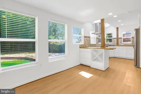 a kitchen with stainless steel appliances granite countertop a sink a stove and a granite counter tops with large windows