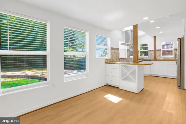 a kitchen with stainless steel appliances granite countertop a sink a stove and a granite counter tops with large windows