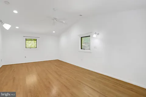 an empty room with wooden floor and window