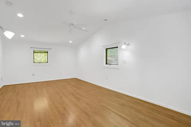 an empty room with wooden floor and window