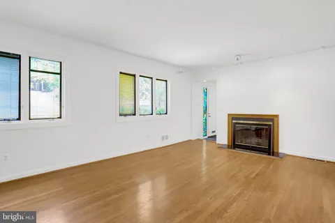 a view of an empty room with a window and fireplace